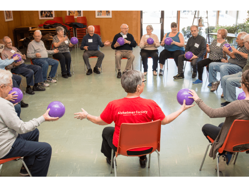 Group of older adults in a circle doing light exercise