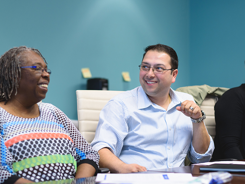 A man and a woman speaking together across a table