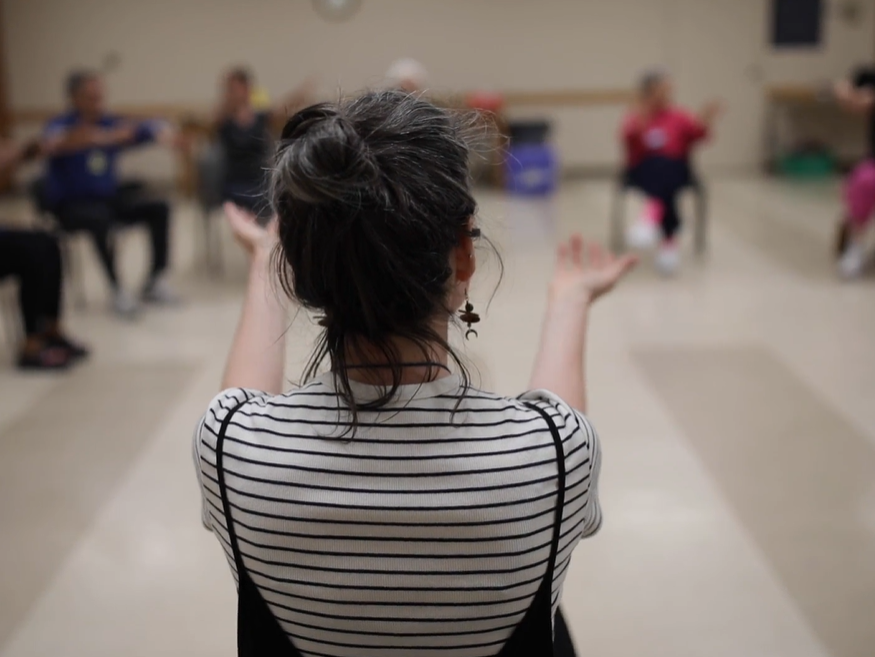 Group of seniors doing exercise in a circle.