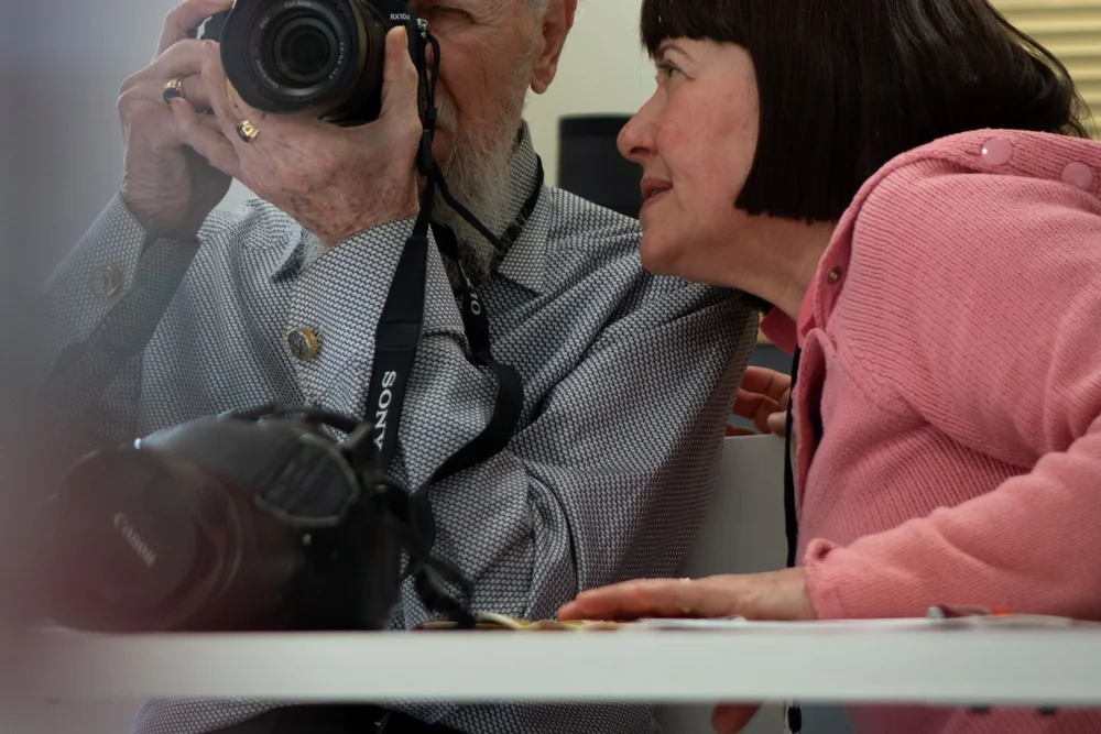Two people using cameras.